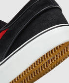 Close-up of black suede sneaker heel with white midsole and gum rubber outsole