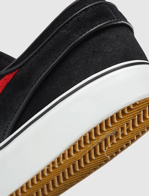 Close-up of black suede sneaker heel with white midsole and gum rubber outsole
