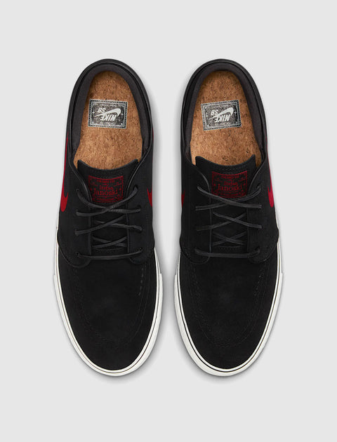 Black suede skate shoes with red accents, cork insoles, white rubber soles, top view
