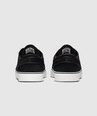 Back view of black streetwear sneakers with white soles and red accents on a neutral background