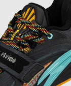 Close-up of black sneaker with multicolor laces, yellow tongue design, blue midsole