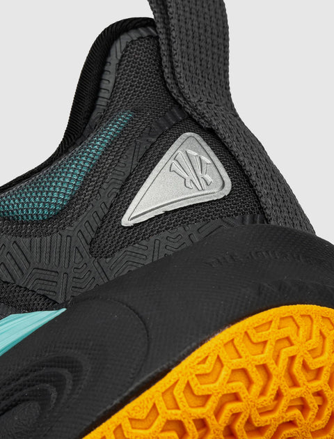Close-up of black athletic sneaker with textured mesh, teal accents, and orange sole