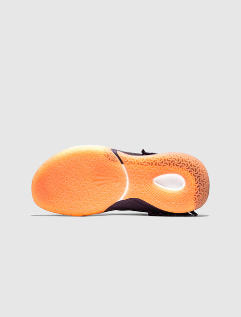 Orange gradient rubber sneaker sole with intricate grip pattern, shown on light grey background