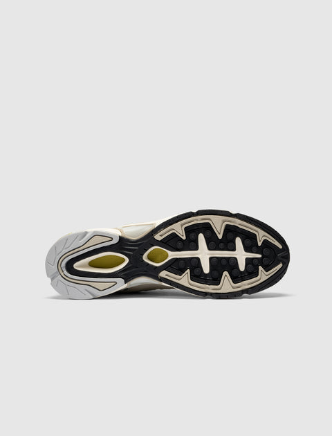 Outsole view of beige and black men's sneaker with textured rubber grip detailing