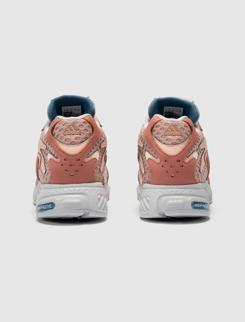 Rear view of pink and beige adidas sneakers with mesh details and white adiPRENE soles