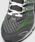 Close-up of men's grey mesh sneaker with green accents and white laces.