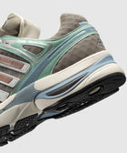 Close-up of a brown and green athletic sneaker with mesh panels and chunky sole