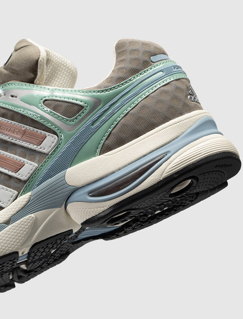Close-up of a brown and green athletic sneaker with mesh panels and chunky sole