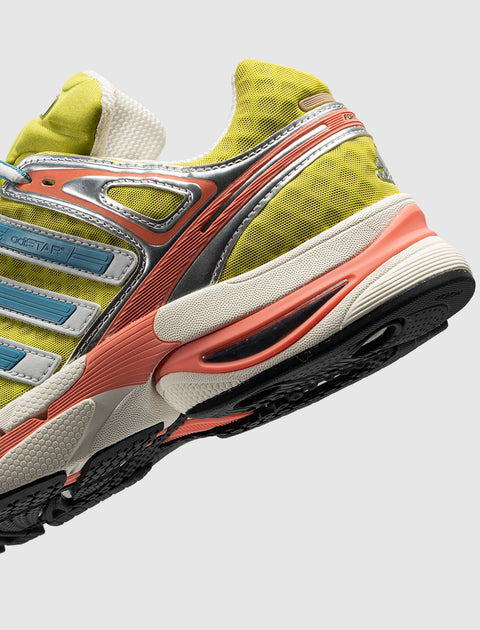 Yellow and beige sneaker with blue accents, mesh upper, and textured rubber sole, side view