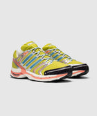 Yellow and blue mesh sneakers with silver accents and colorful sole on white background
