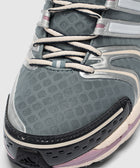 Close-up of grey and purple mesh sneaker with beige laces and black toe detail