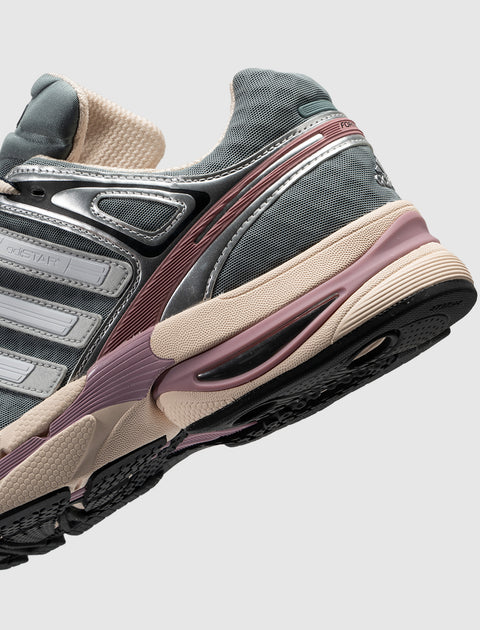 Close-up of grey mesh sneaker with silver, purple, and beige accents on textured sole
