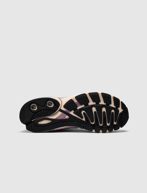 Close-up of sneaker outsole with black and cream tread, torsion system detail visible