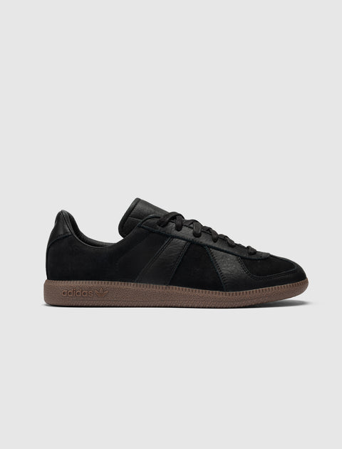 Black low-top sneaker with suede upper and brown gum sole, minimalist streetwear shoe