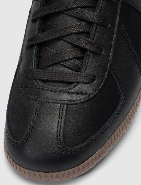 Close-up of black leather sneaker with gum sole and black laces