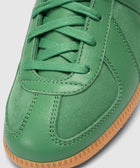 Close-up of green leather sneaker with matching laces and gum rubber sole