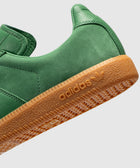 Close-up of green adidas sneaker with gum sole and embossed logo