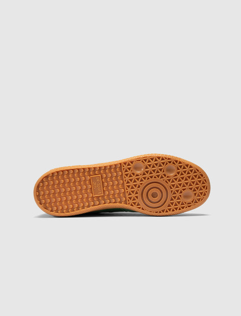 Gum rubber sole of a sneaker with geometric tread pattern, photographed against white background