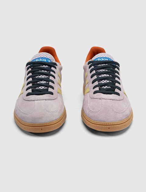 Lilac suede sneakers with yellow stripes, gum soles, black laces, orange interior, front view