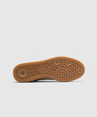 Gum sole of a sneaker with geometric tread pattern and adidas logo, on light background