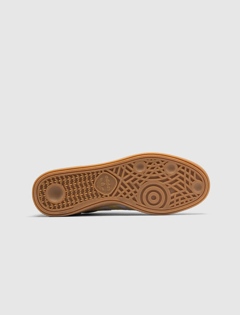 Gum sole of a sneaker with geometric tread pattern and adidas logo, on light background