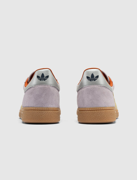 Back view of lilac suede sneakers with gum soles and silver heel tabs featuring trefoil logo