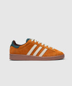 Orange suede low-top sneaker with cream stripes, teal heel accent, and brown sole on white background