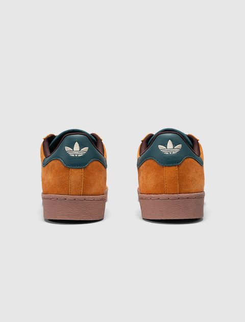 Back view of brown and teal suede sneakers with white Adidas trefoil logo on heel