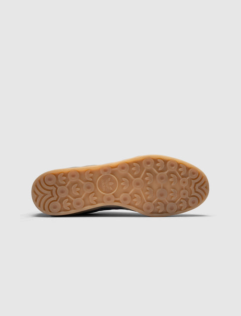 Gum sole of navy and purple sneaker with textured Adidas logo pattern