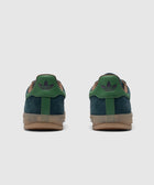 Rear view of green and navy suede sneakers with gum sole on white background