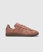 Salmon pink low-top leather sneaker with textured brown sole on white background