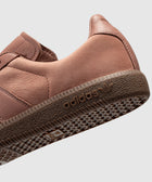 Close-up of salmon pink Adidas sneaker with textured sole and logo, streetwear footwear