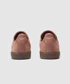 Back view of salmon pink suede low-top sneakers on light background