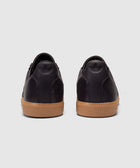Back view of dark purple low-top sneakers with gum soles on a plain background