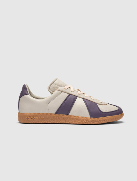 Beige and purple leather sneaker with gum sole, side view on plain background