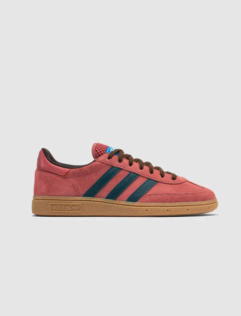 Red suede sneaker with blue stripes, brown laces, and gum sole on white background