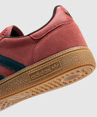 Red suede sneaker with gum sole, dark blue stripe, and adidas logo on the midsole