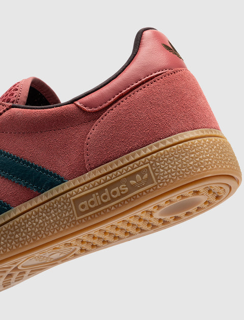 Red suede sneaker with gum sole, dark blue stripe, and adidas logo on the midsole