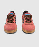 Pair of red and blue suede sneakers with gum soles and brown laces on white background