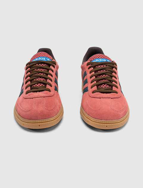 Pair of red and blue suede sneakers with gum soles and brown laces on white background