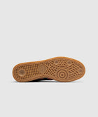 Gum sole of a sneaker with intricate tread pattern and adidas logo, isolated on light background.