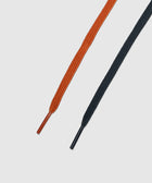 Close-up of orange and black flat shoelaces on a white background