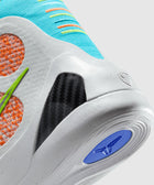 Close-up of colorful athletic sneaker with turquoise upper, orange details, and carbon fiber heel support