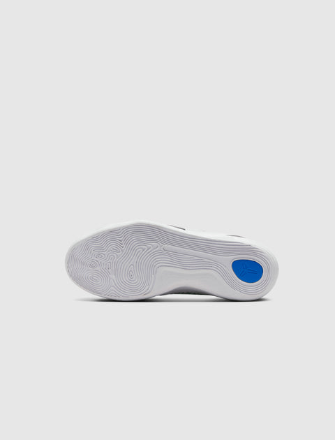 White sneaker outsole with wavy traction pattern and blue accent on heel, studio background