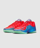 Bright red low-top sneakers with blue and teal accents, mint green soles, and purple tongue.