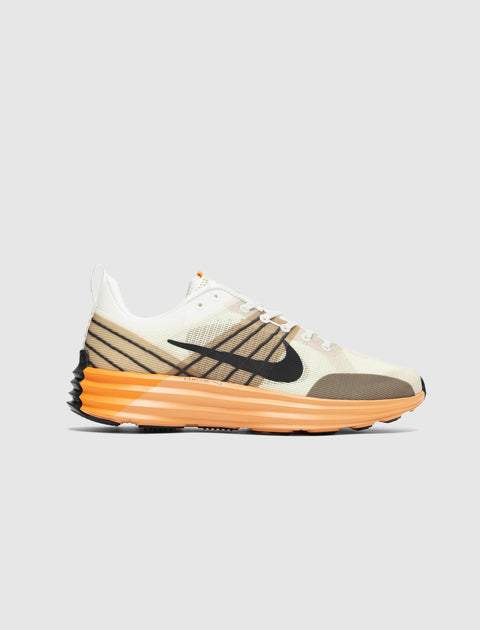 Men's beige and brown streetwear sneaker with orange sole and black accents on white background