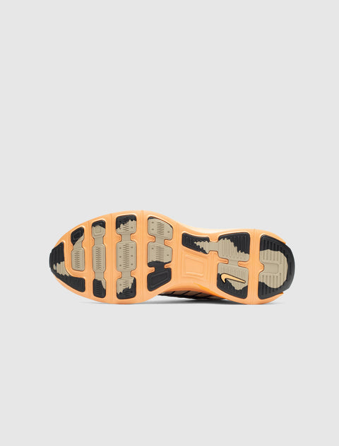 Brown and tan sneaker outsole with textured grip, viewed from the bottom against a gray background.