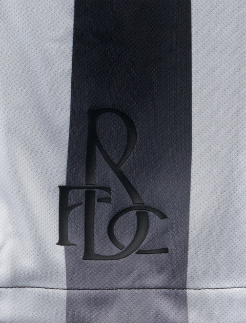Close-up of black embroidered logo on black and white striped men's streetwear fabric