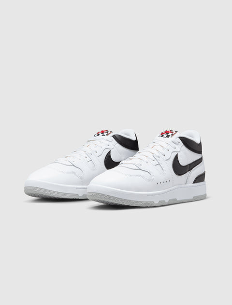 White and black low-top sneakers with checkered tongue detail on a plain background