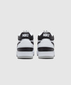 Back view of black and white low-top Nike sneakers on plain background